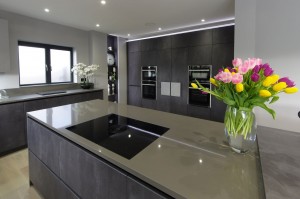 Concrete graphite kitchen with island and secret doors to utility room. Open decorative shelving